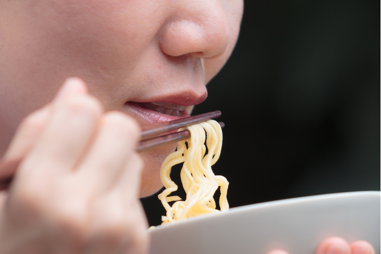 カップラーメンを食べる女性のイメージ