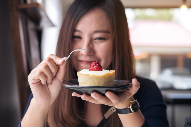 ケーキを美味しく食べている女性のイメージ