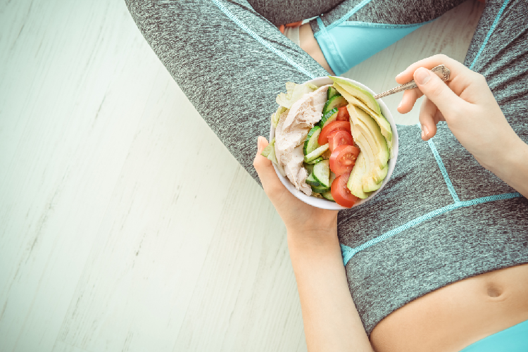 鶏肉のサラダを食べる女性
