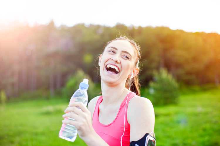 笑顔で水を飲む女性