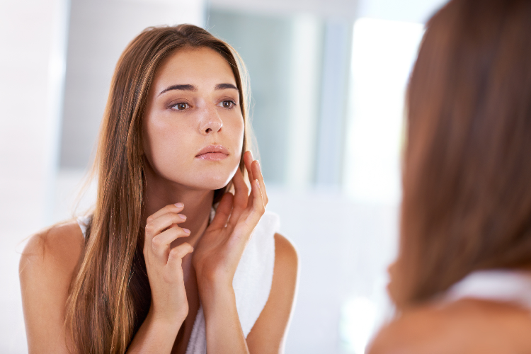 鏡で肌の調子を確認する女性