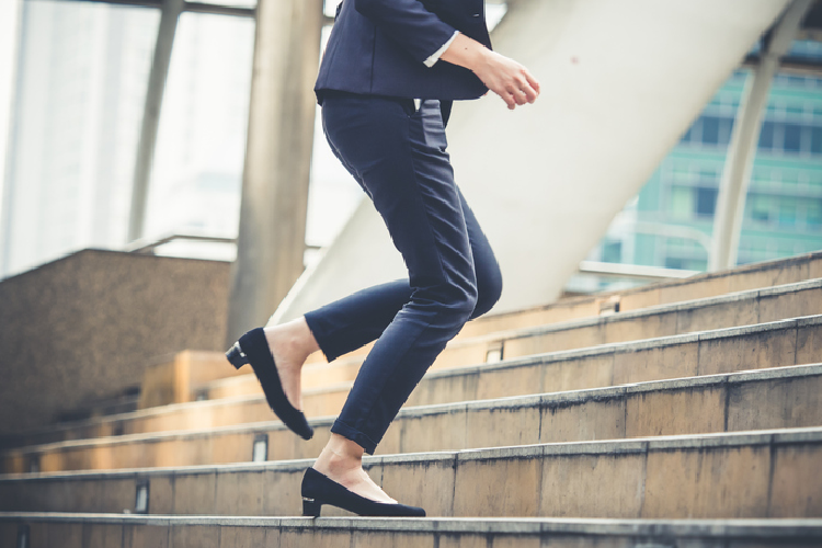 階段を登るスーツ姿の女性