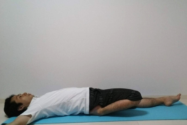 仰向けで膝のストレッチをする人