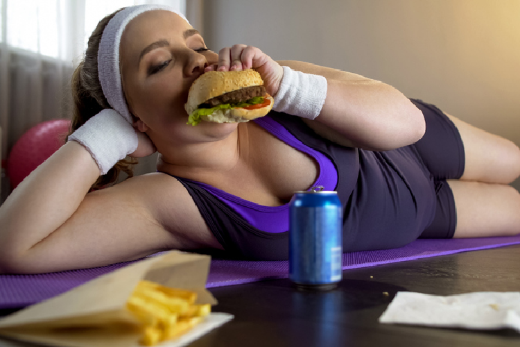 スポーツウェアを着てハンバーガーを食べる女性
