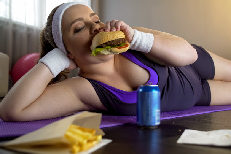 マットの上でハンバーガーを食べる女性