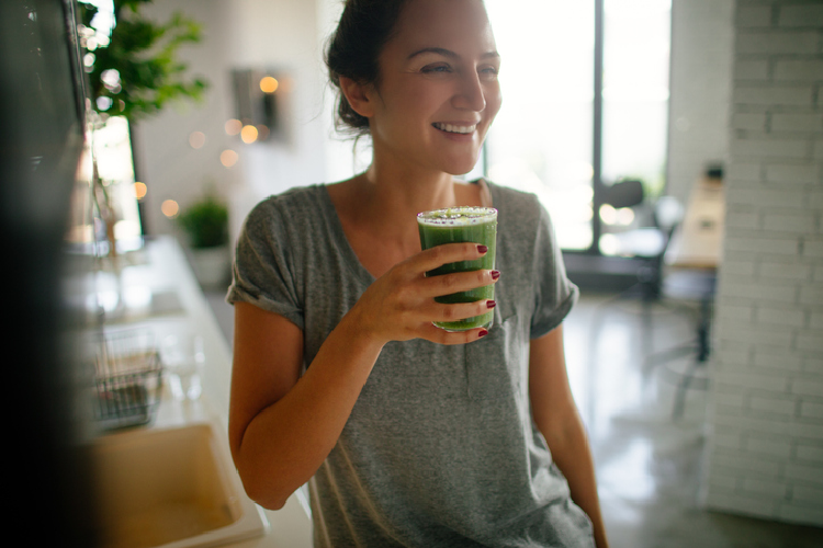 野菜ジュースを飲む女性