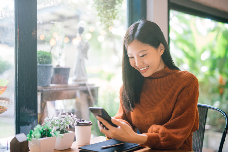 カフェでスマホを使用する女性