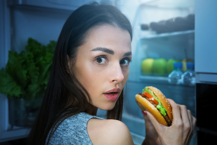ハンバーガーを食べる女性