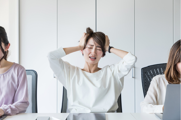 頭をかかえる女性