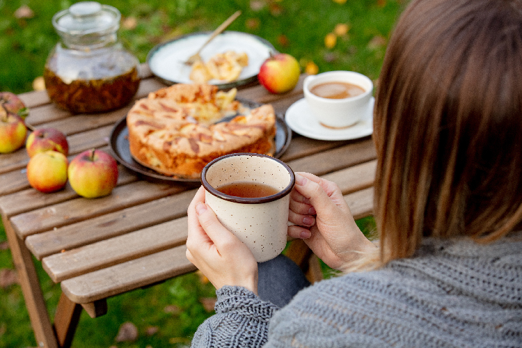 庭でアップルパイを食べる女性