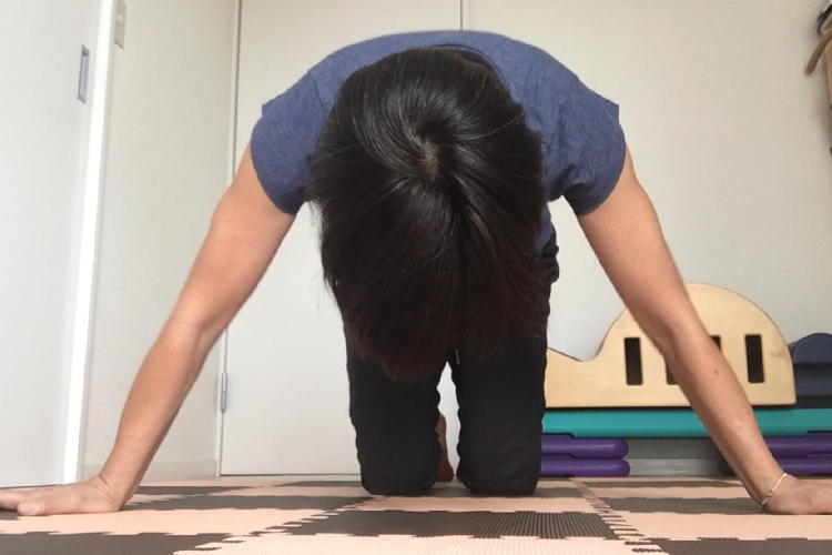背中を丸める女性