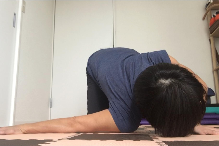 右肩を床につく女性