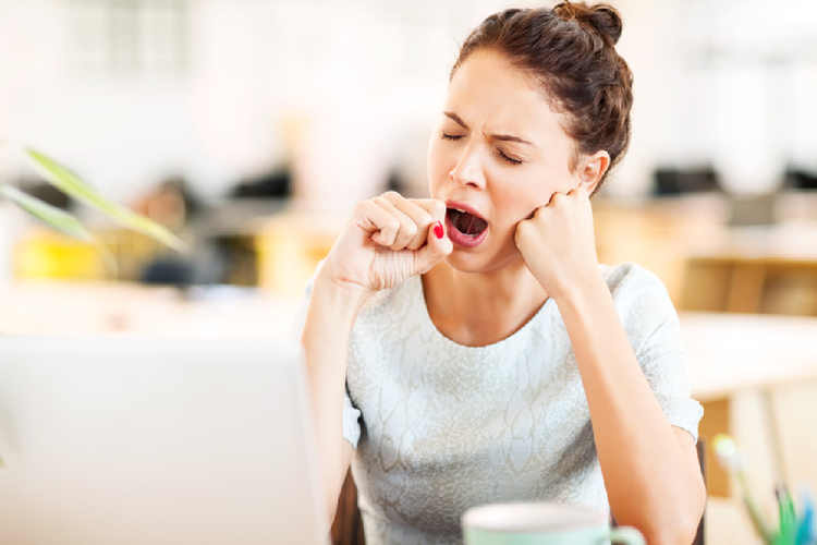 オフィスであくびをする女性