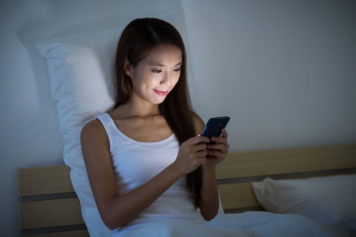 夜にスマホを使うイメージ