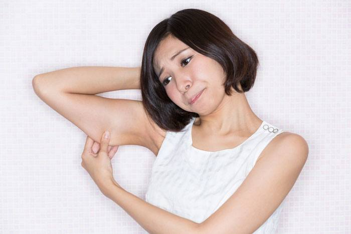 二の腕が太くて悩んでいる女性のイメージ