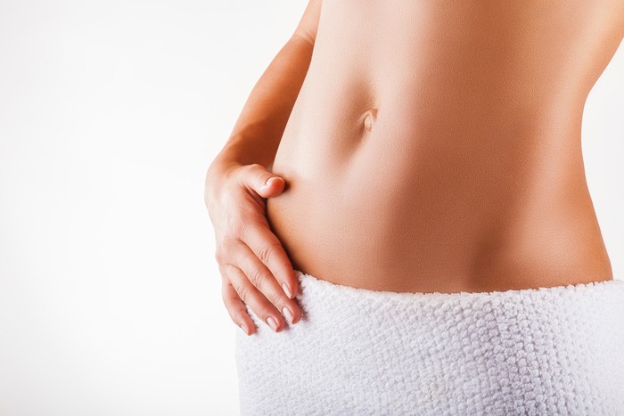 女性がお腹をキュッと凹ませているイメージ