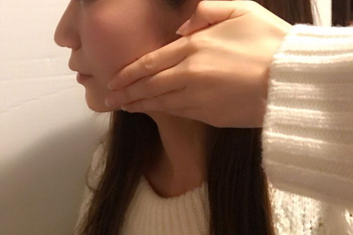 両手指の腹で顎の中心から耳下に向かって撫で上げているイメージ